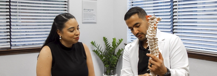 Dr. Jorge Ayala demonstrates spine structure to a patient during an evaluation session.